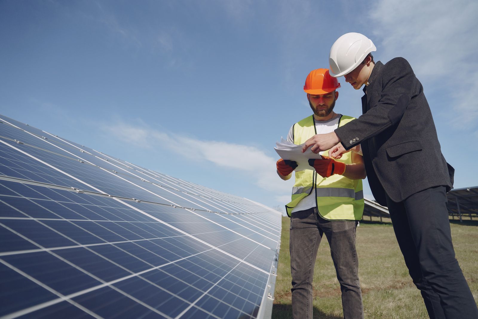Ingenieros con casco inspeccionando una instalación solar