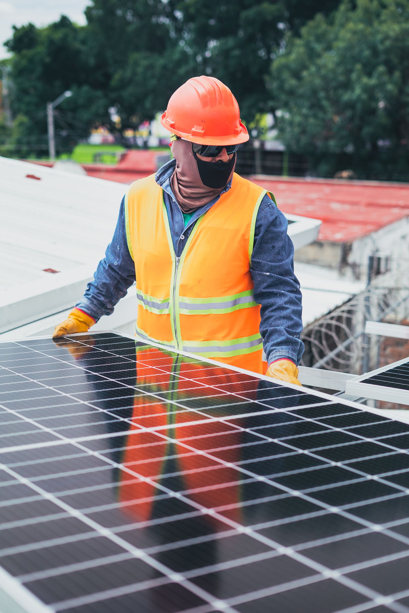 Técnico con equipo de protección instalando paneles solares