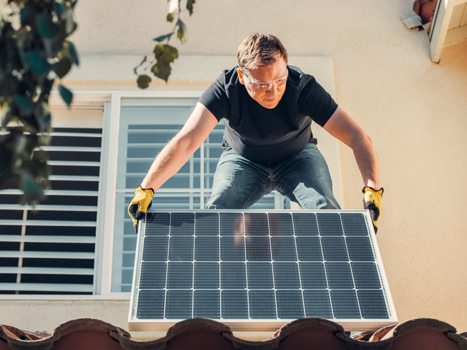 Instalador con gafas de seguridad montando un panel solar